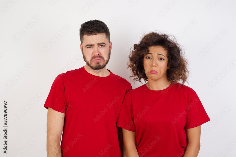 Portrait of displeased upset Young beautiful couple wearing red t-shirt on white frowns face as going to cry, being discontent and unhappy as can't achieve goals, Disappointed young man has troubles Portrait of displeased upset Young beautiful couple wearing red t-shirt on white frowns face as going to cry, being discontent and unhappy as can't achieve goals, Disappointed young man has troubles