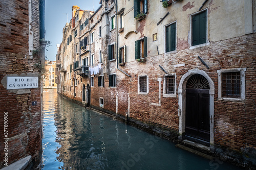 Fototapeta Naklejka Na Ścianę i Meble -  Streets of Venice with a typical waterl canal during a sunny day, Italy