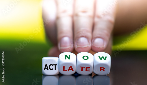 Hand turns dice and changes the expression "act later" to "act now".