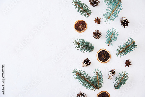 Christmas composition with copy space. Decoration made of fir tree branches, pine cones and dried fruits on a white background