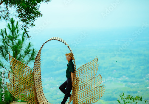 Single Asian girl having fun on mountain park at Hutan Pinus Pengger, Yogyakarta, Indonesia. photo