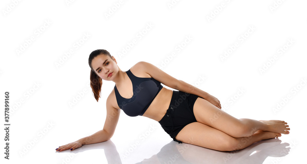 Serious woman doing pilates exercise on floor