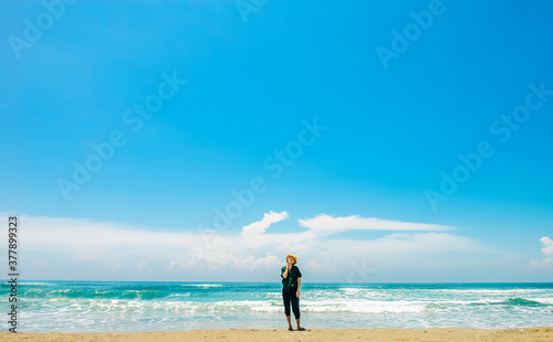 single girl enjoys herself standing on Parangtritis beach, Yogyakarta, Indonesia.