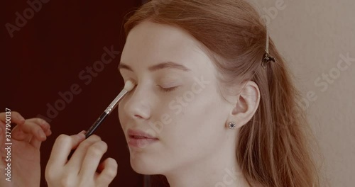 Makeup is applied to a beautiful young girl in the salon.