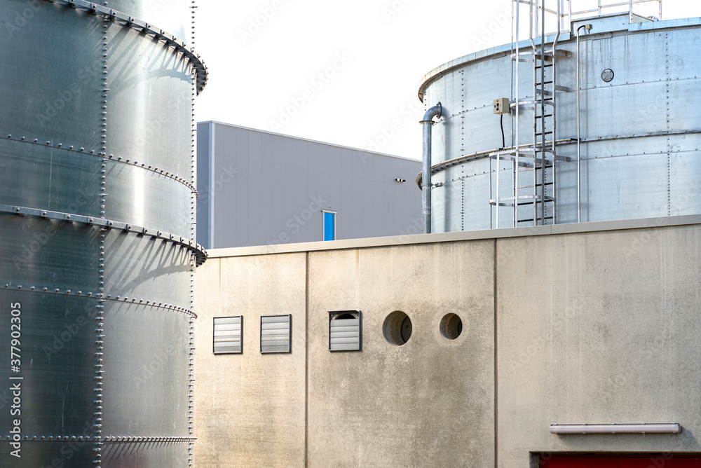 Steel industrial silos for liquids and solids standing in a factory