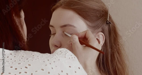 Makeup is applied to a beautiful young girl in the salon.