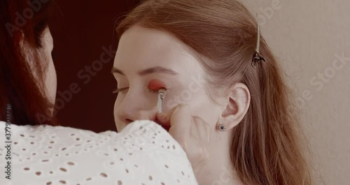 Makeup is applied to a beautiful young girl in the salon.
