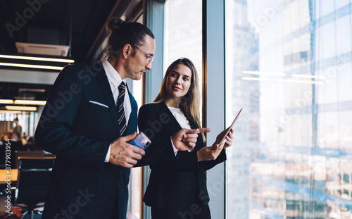 Formal colleagues in modern spacious office talking over new project