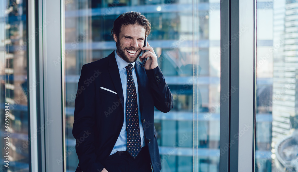 Elegant business man in modern office talking on cellphone laughing cheerfully Elegant business man in modern office talking on cellphone laughing cheerfully