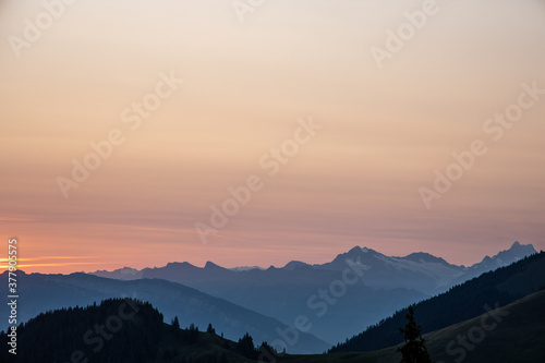 Schweizer Alpen im Sonnenaufgang, Berge am Horizont, rot gefärbter Himmel im Hintergrund, Herbst Morgenstunde