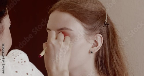 Makeup is applied to a beautiful young girl in the salon.