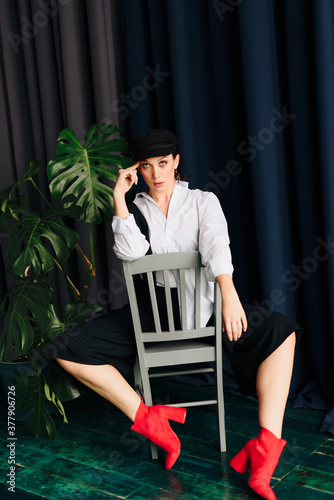 Portrait of a beautiful young woman in a white shirt and black pants in the Studio