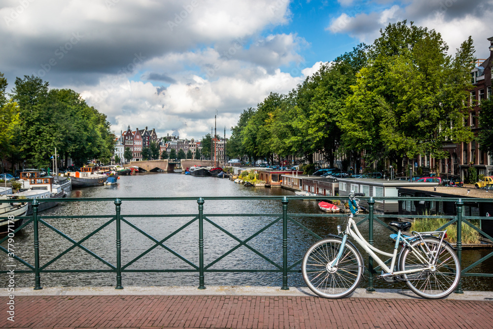 bike against the railing of a canal bridge in Amsterdam, Netherlands