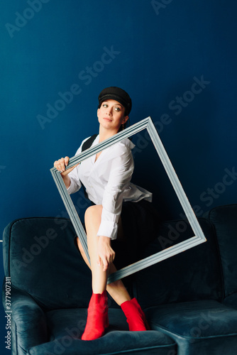 Portrait of a beautiful young woman in a white shirt and black pants in the Studio