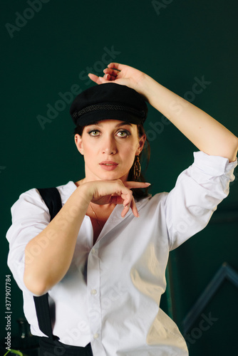 Portrait of a beautiful young woman in a white shirt and black pants in the Studio