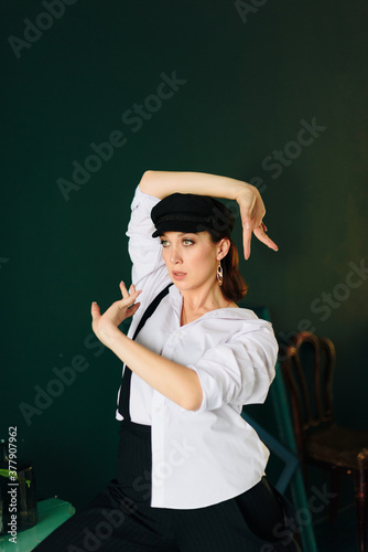 Portrait of a beautiful young woman in a white shirt and black pants in the Studio