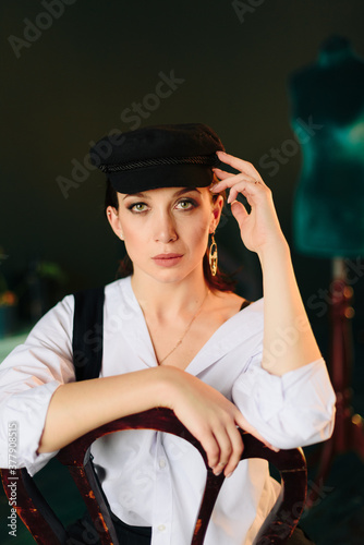 Portrait of a beautiful young woman in a white shirt and black pants in the Studio