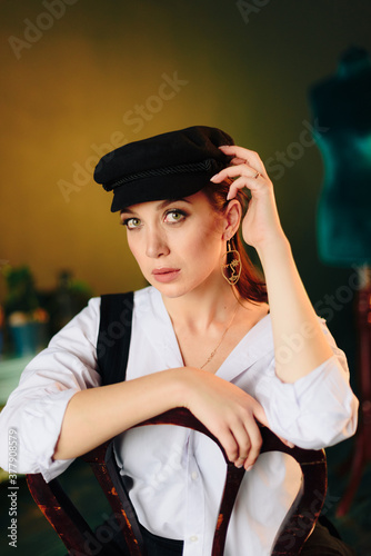 Portrait of a beautiful young woman in a white shirt and black pants in the Studio