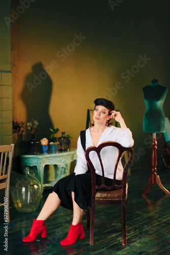 Portrait of a beautiful young woman in a white shirt and black pants in the Studio