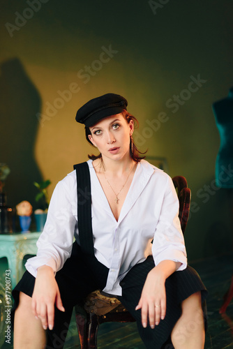 Portrait of a beautiful young woman in a white shirt and black pants in the Studio