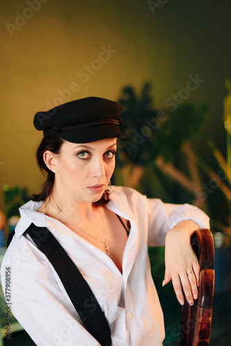 Portrait of a beautiful young woman in a white shirt and black pants in the Studio