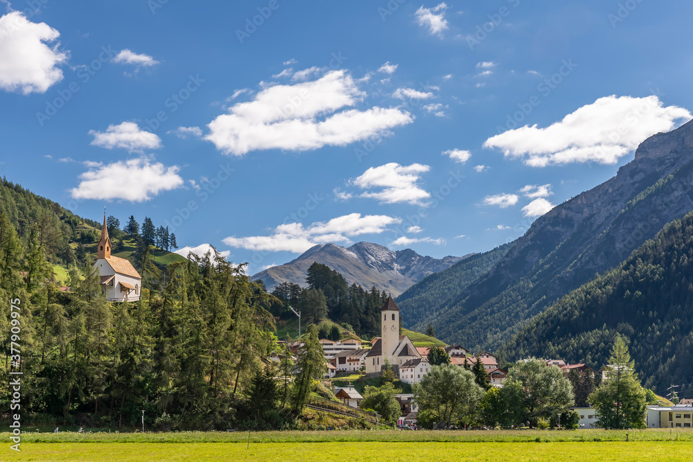 The mountain village of Curon (Graun) in Val Venosta, against a beautiful sky, on a sunny summer day, South Tyrol, Italy
