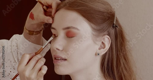 Makeup is applied to a beautiful young girl in the salon.