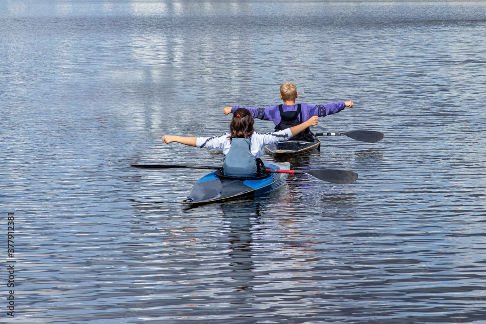 Young girl and boy train to keep balance on a kayak, canoe. Water sports. The training process.