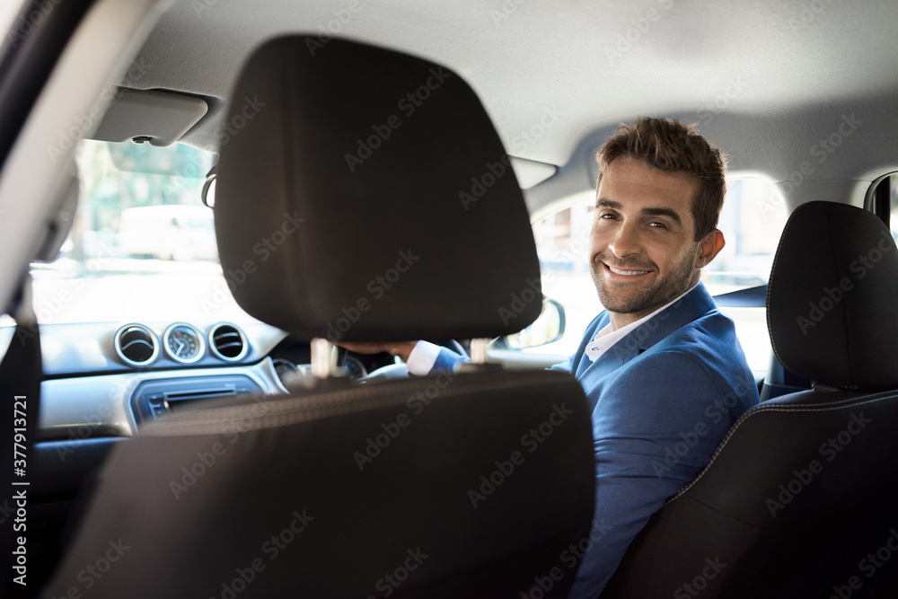 Friendly driver looking over his shoulder and smiling