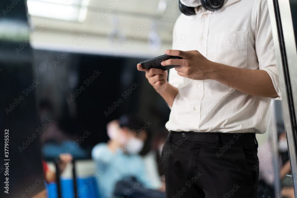 Young Hand some Asian business man with smartphone in public transport electric train. Young Hand some Asian business man with smartphone in public transport electric train.