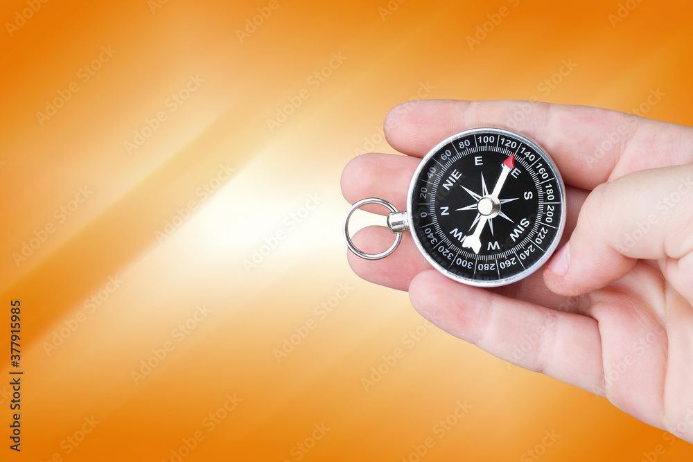 round compass in hand on abstract background as symbol of tourism with compass, travel with compass and outdoor activities with compass round compass in hand on abstract background as symbol of tourism with compass, travel with compass and outdoor activities with compass