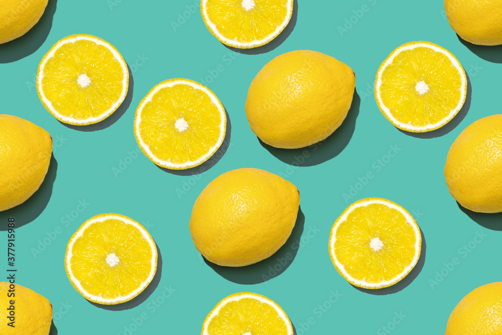 Top view of fresh lemon seamless pattern on green background. Many sliced and whole yellow lemons seamless texture and blue background. Yellow blue fruit minimal concept.