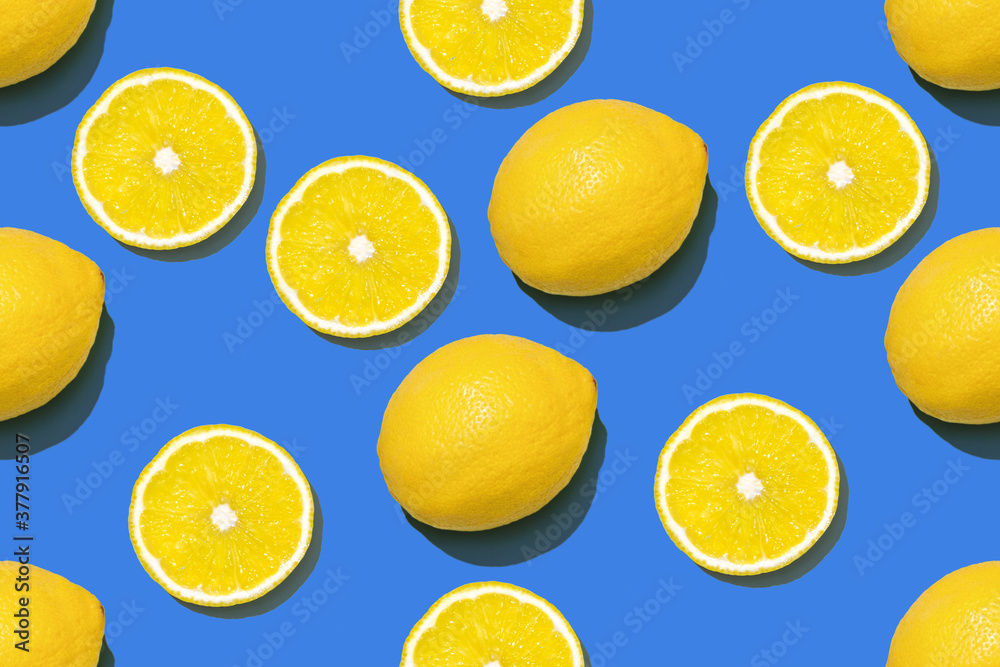 Top view of fresh lemon seamless pattern on blue background. Many sliced and full yellow lemon seamless texture and blue background. Yellow blue fruit minimal 