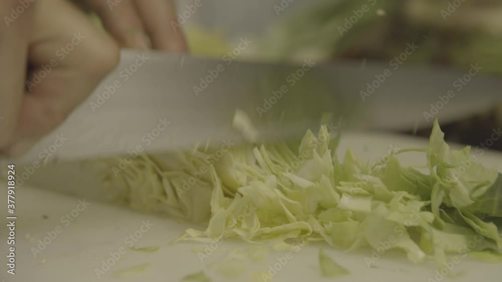 close up of hands slicing a lettuce in a kitchen close up of hands slicing a lettuce in a kitchen