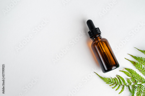 Bottle of Spa essential oil for aromatherapy with  leaflet. Bottles of essence and surum for skin health on white background. Natural herbal Skin care cosmetics in dark glass. Mockup advertising. 