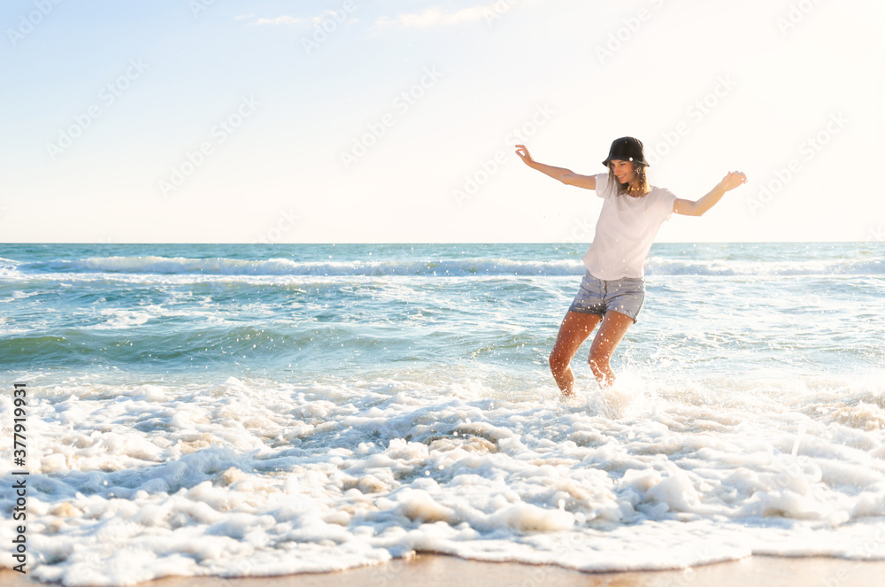 Funny young woman playful on sunset beach. Beautiful happy female on the shore of the blue sea having fun playing splashing water, positive mood, summer vacation, sunny concept Funny young woman playful on sunset beach. Beautiful happy female on the shore of the blue sea having fun playing splashing water, positive mood, summer vacation, sunny concept