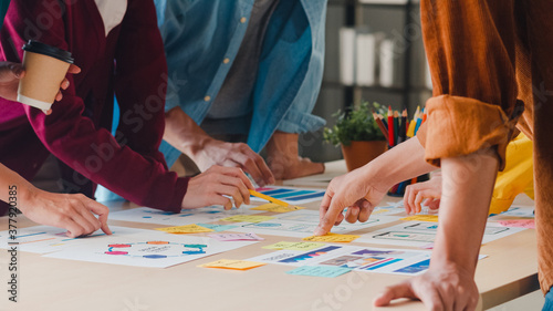 Obraz na płótnie Asian businessmen and businesswomen meeting brainstorming ideas about creative web design planning application and developing template layout for mobile phone project working together in small office