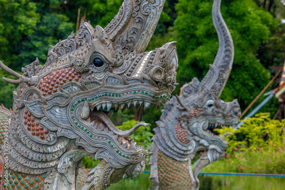 Fototapeta premium The background of the Wat Pa Kham Charoen is a beautiful old church with a Buddhist statue and a tree-lined temple, with tourists and travelers always making merit in Udon Thani, Thailand.