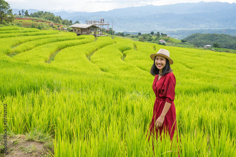 beautiful Asian woman, a tourist wearing a red dress, admiring the terraces of northern Thailand

