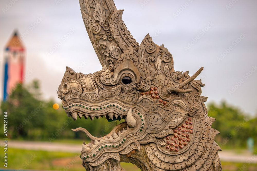 Fototapeta premium The background of the Wat Pa Kham Charoen is a beautiful old church with a Buddhist statue and a tree-lined temple, with tourists and travelers always making merit in Udon Thani, Thailand.