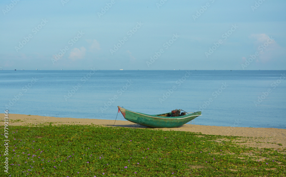 a green boat park at the sand beach a green boat park at the sand beach