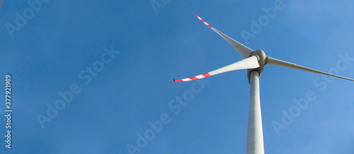 Windmill on a background of blue sky. Bottom view. Clean energy concept