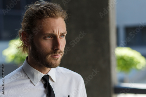 Portrait of a handsome curly-haired man, in a business style. The astute look of an attractive businessman.