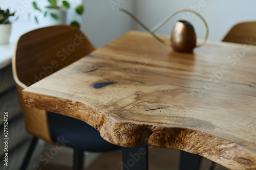 Stylish compositon of craft oak wooden table with chairs, copper watering can and modern floor in beautiful orangery. Template. photo