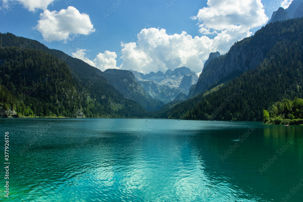 View of majestic mountains and lake in Europe.Nature getaway.Turquoise water of Gosau See,lake,Austria,Dachstein glacier in background.Vacation travel scene.Alpine lake surrounded by mountains