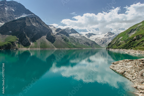 Beautiful view of high mountain lake near Kaprun.Hike to the Mooserboden dam in Austrian Alps.Quiet relaxation in nature.Wonderful nature landscape,turquoise tranquil lake,holiday travel scene © Eva
