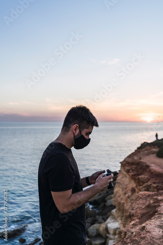 Chico joven tomando fotografías en un acantilado de Cadiz