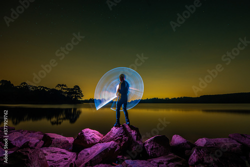 Painting with light bat on a dam, night landscape photo