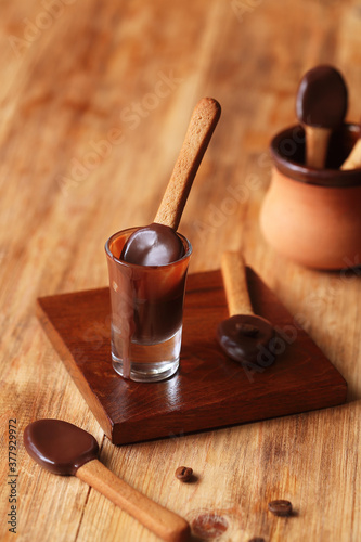 Spoon-Shaped Coffee Cookies dipped in dark chocolate, on a wooden table.