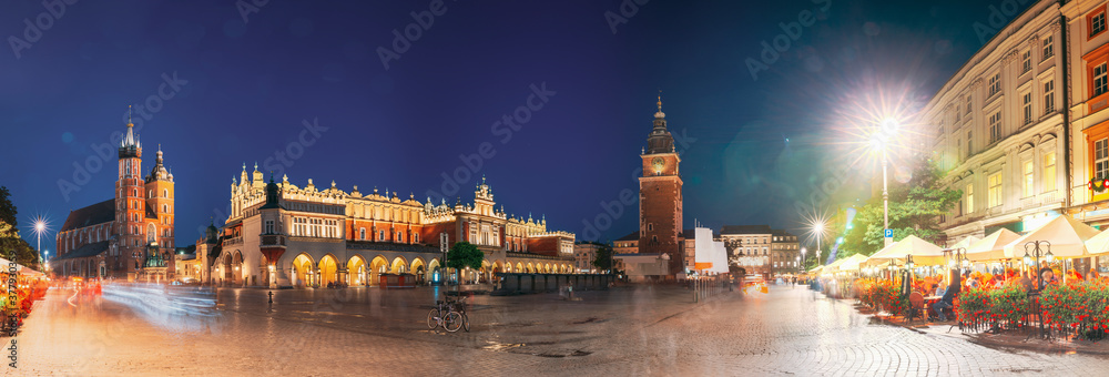 Krakow, Poland. Famous Landmarks On Old Town Square In Summer Evening. St. Mary's Basilica, Cloth Hall Building And Old Town Hall Tower In Night Lighting. UNESCO World Heritage Site. Panoramic View